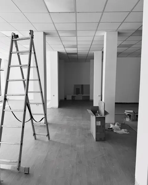 Prazan prostor budućeg studija, crno-bela fotografija sa merdevinama