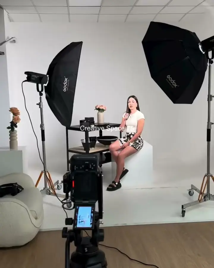 Foto studio: fotoaparat na stativu, model na belom postolju i Godox softboksovi
